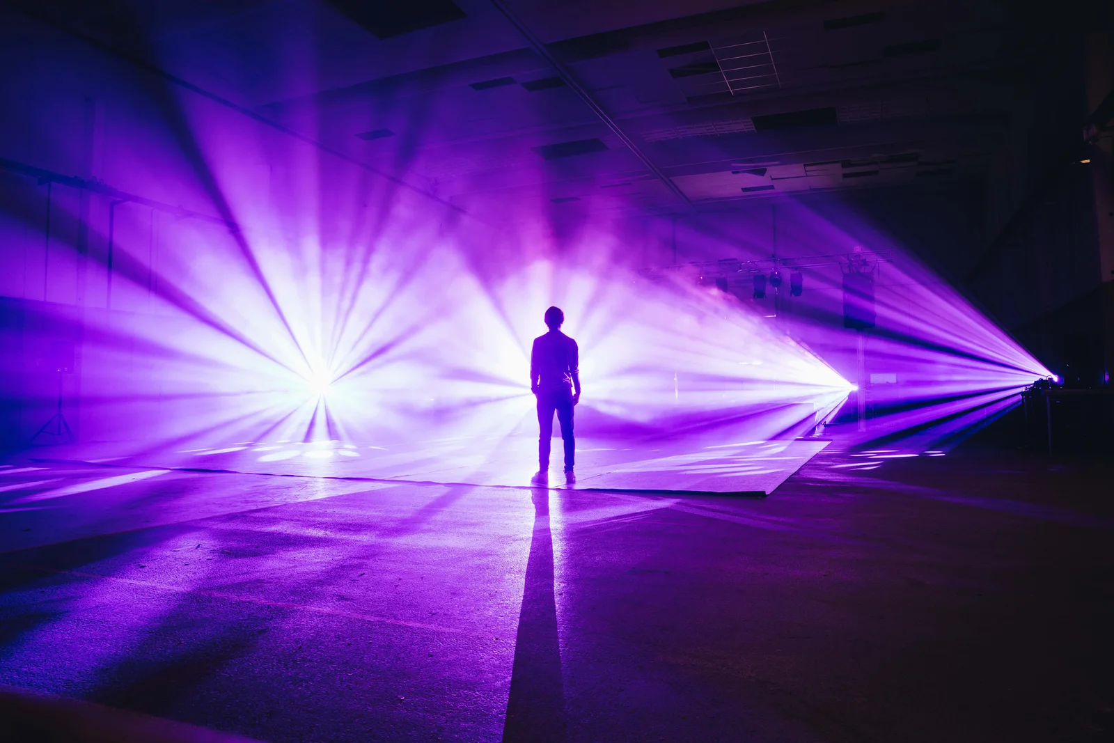 A silhouette surrounded by violet beams of light at CLICK Festival.