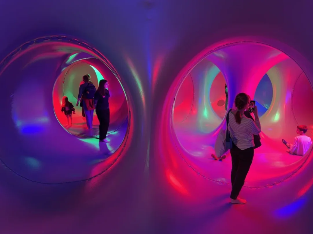 Besøgende i en farverig lysinstallation.